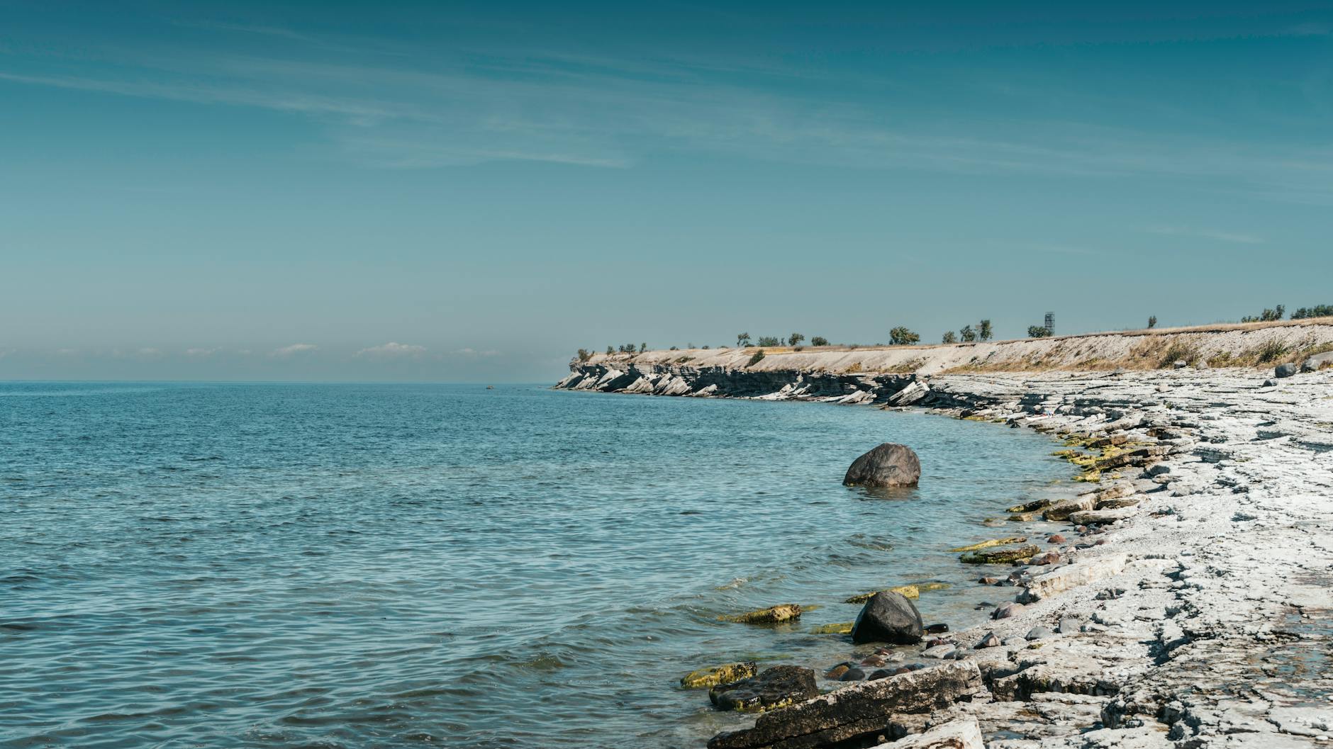 Skaliste klify nad spokojnym, błękitnym Bałtykiem w słoneczny dzień