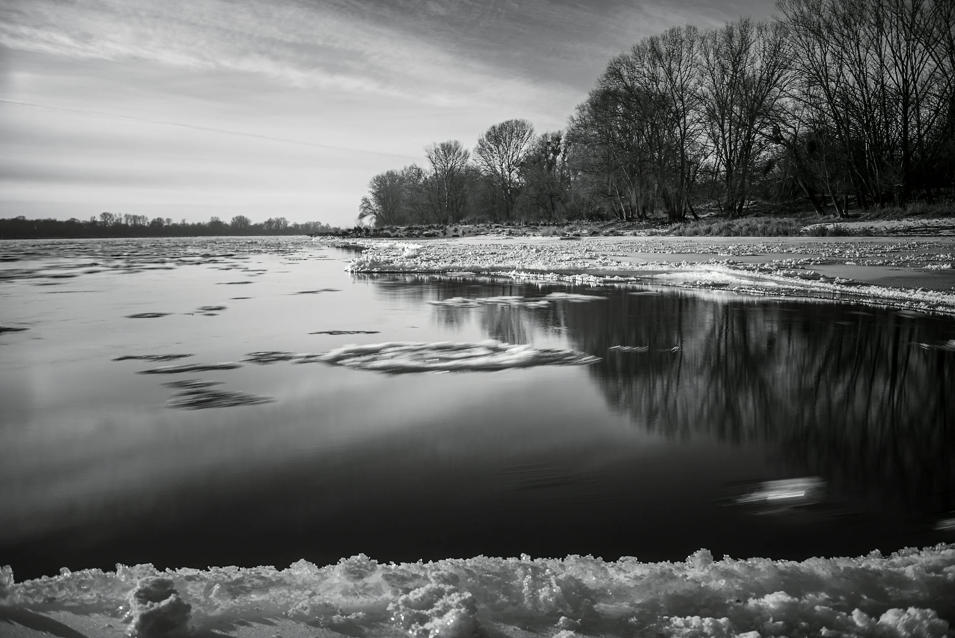 Zimowy widok na zamarzniętą Wisłę z ośnieżonym brzegiem