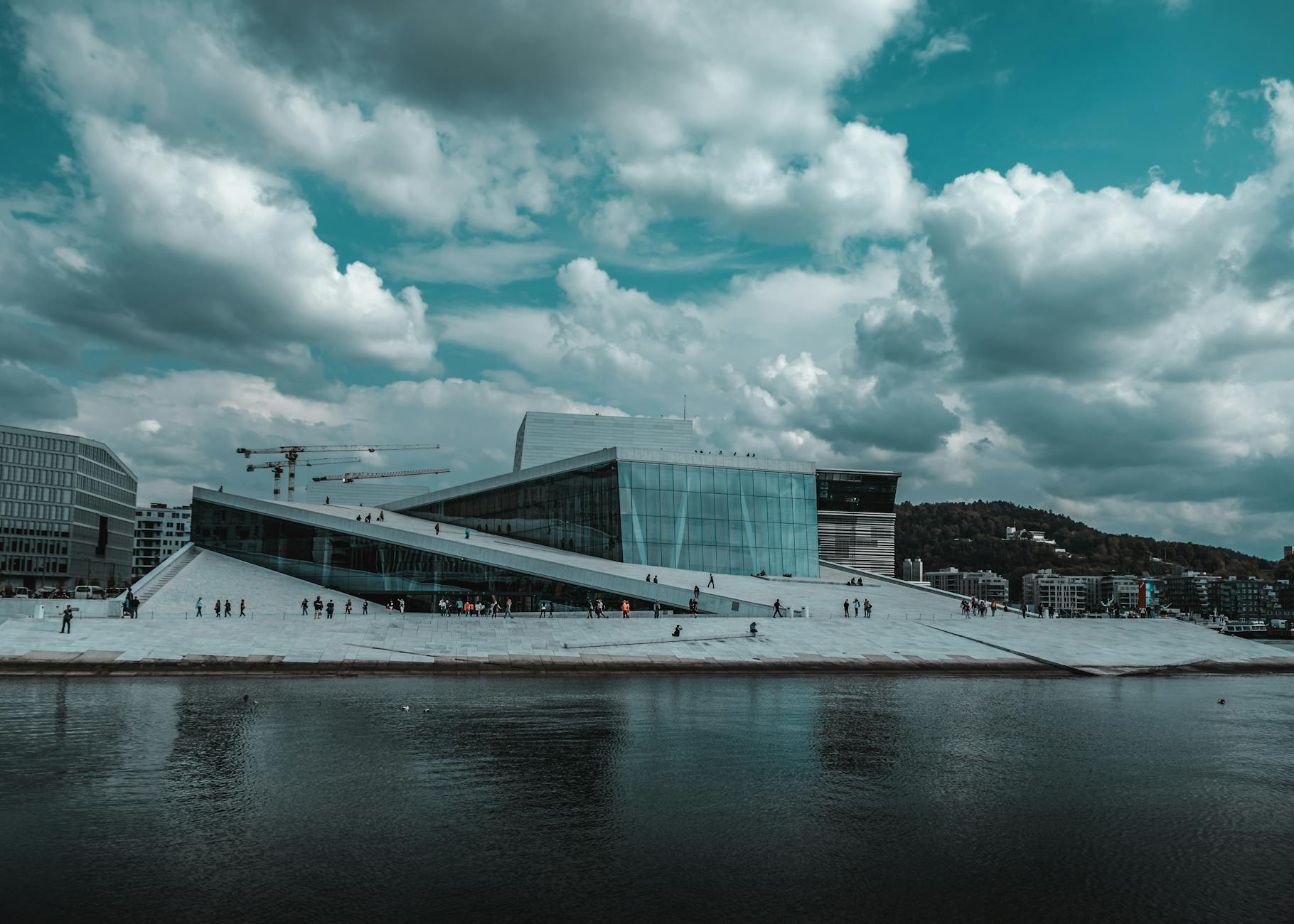 Opera w Oslo nad wodą, odbijająca się w tafli przy burzowych chmurach