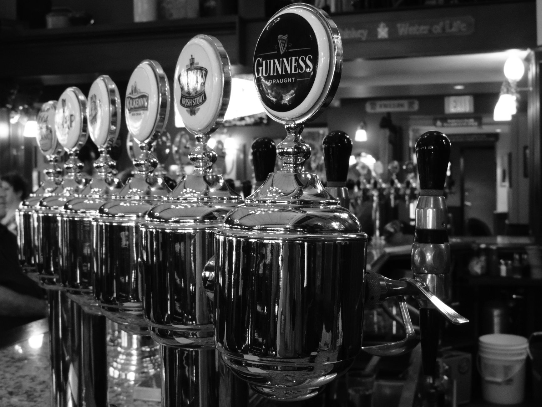 Nalewaki piwa w irlandzkim pubie z widocznym logo Guinness